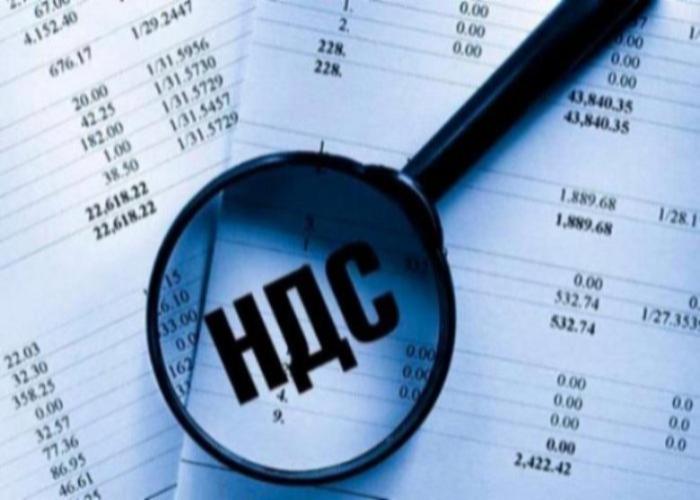 Рукопожатие бизнесменов на фоне документов и ноутбука с графиками НДС